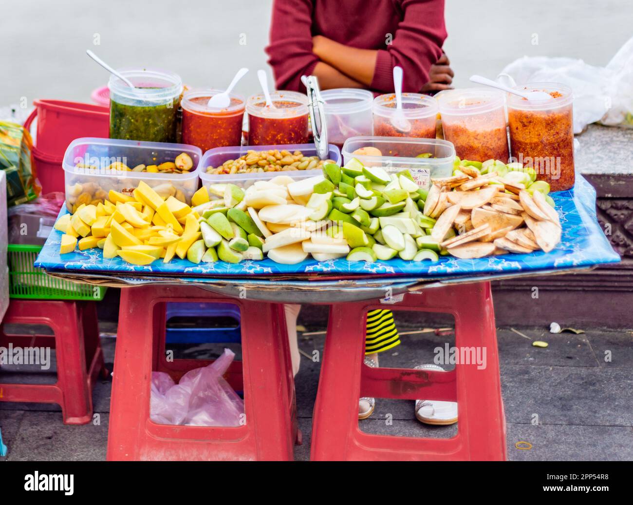 Tasty morsels including mango,papaya,dates and a variety of spicy sauces,on display,for passing pedestrians,on a small colorful stall on the river wal Stock Photo