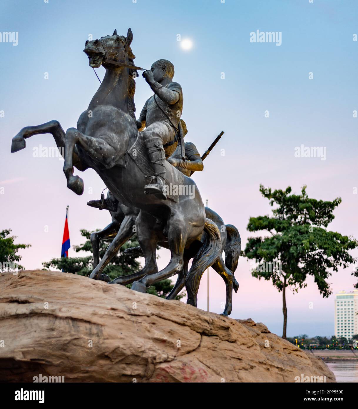 Placed on a large rock,moonshine at dusk,along Riverside walk.Life-size bronze sculpture of two horses,one rearing up defiantly,mounted by heroic,hist Stock Photo