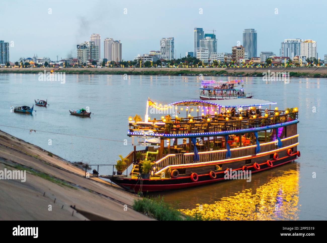 Illuminated with vibrant,strip lights to attract tourists,the river craft,big and small,take trips up and down the Tonle Sap and Mekong rivers,visitin Stock Photo