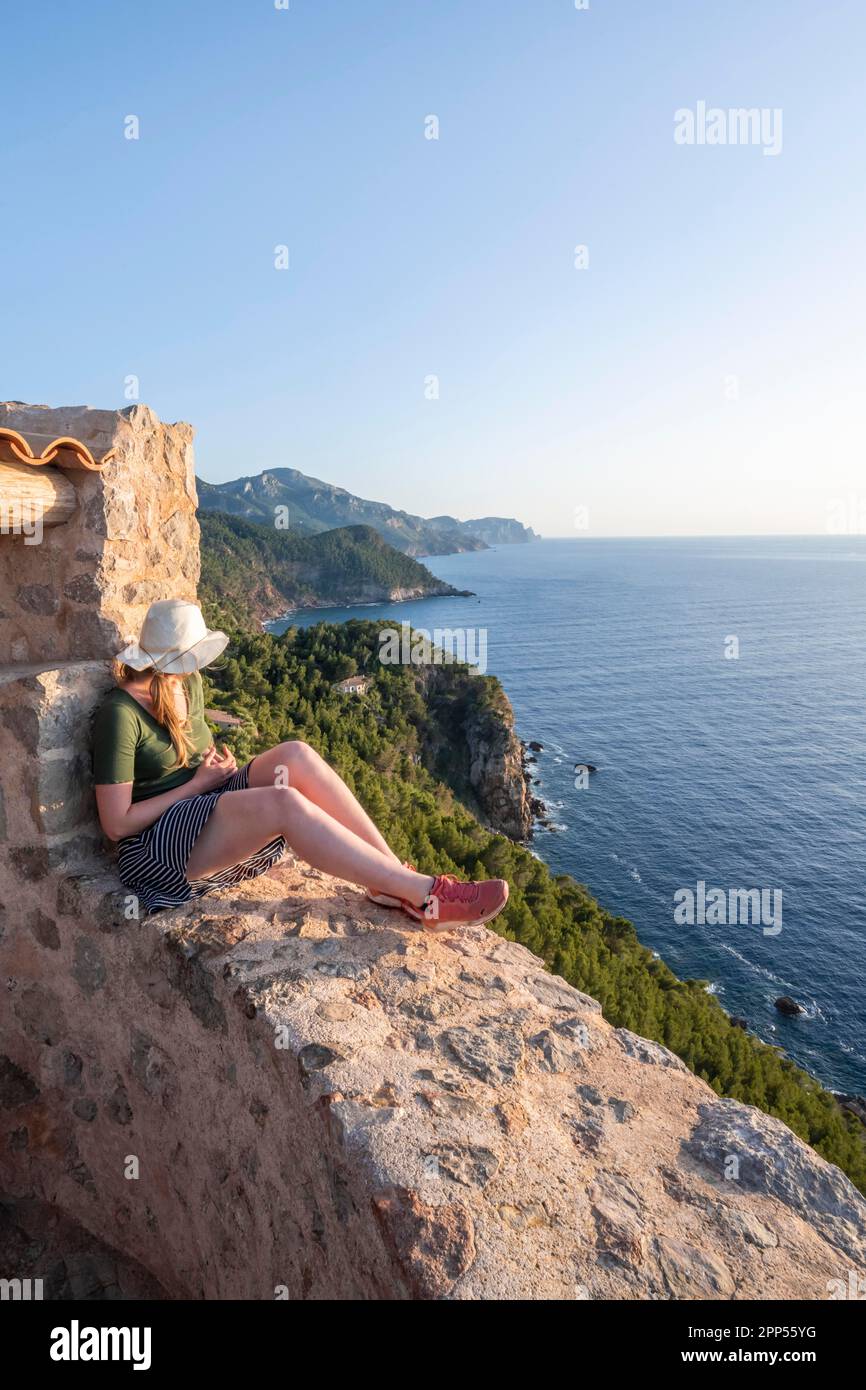 Young tourist at the Torre des Verger, stone tower on the coast, sea view, Banyalbufar, Majorca, Balearic Islands, Spain Stock Photo