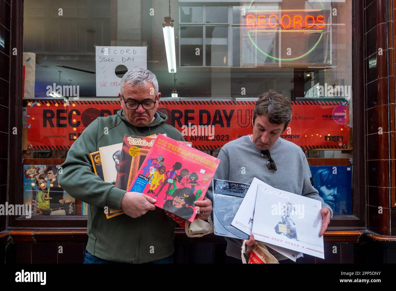 London, UK.  22 April 2023.  Customers with purchases outside Sounds of the Universe, a record store in Soho, on Record Store Day, where independent record shops worldwide celebrate music, including special vinyl releases made exclusively for the day. According to the Entertainment Retailers Association (ERA), vinyl has outsold CD for first time in 35 years, and for cassettes, 195,000 were bought in 2022, up 5.2 per cent in a year and the tenth annual consecutive increase, according to the British Phonographic Industry (BPI). Credit: Stephen Chung / Alamy Live News Stock Photo
