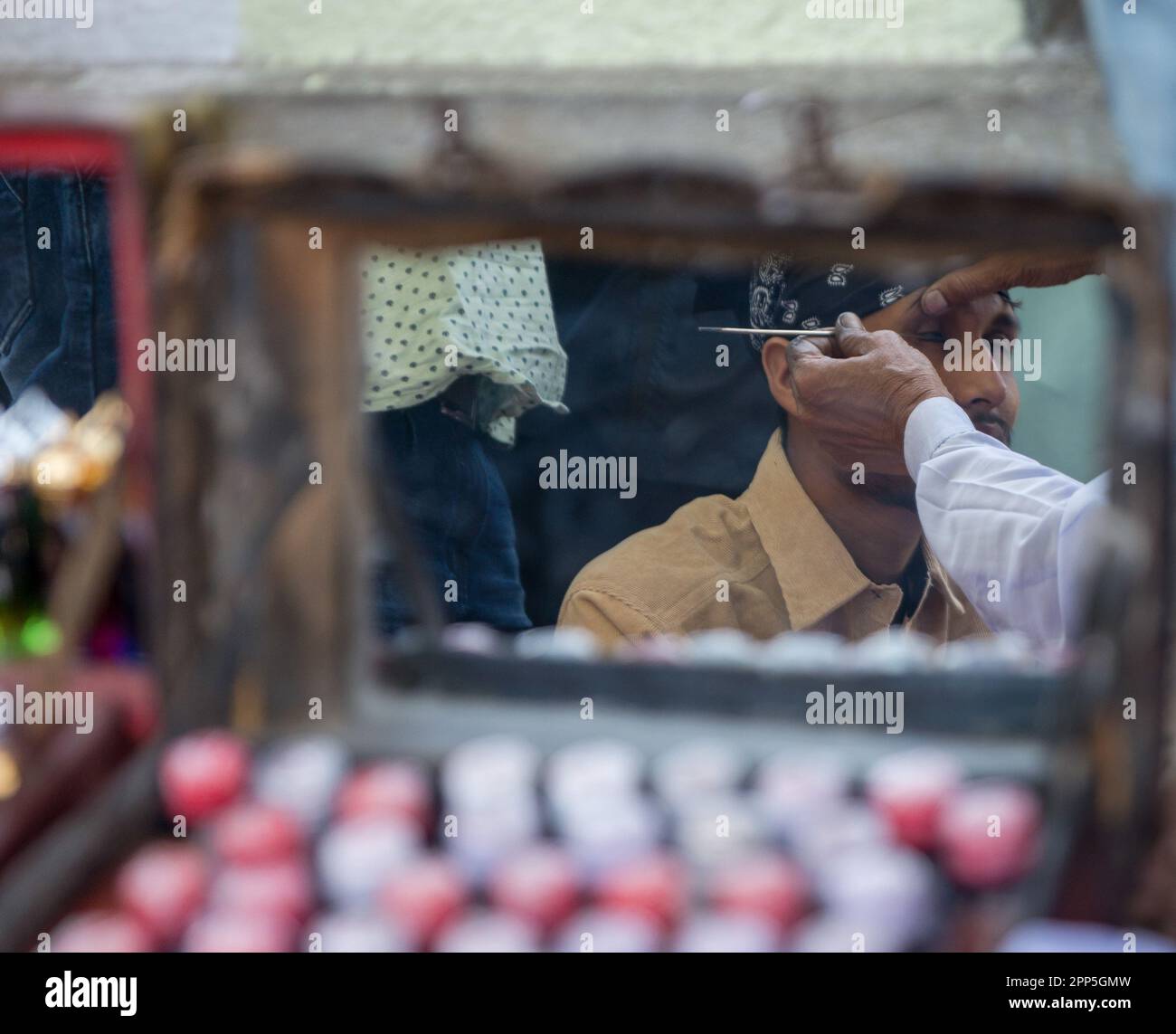 Kathmandu, Nepal. 22nd Apr, 2023. A reflection of a Nepalese Muslim in the mirror applying