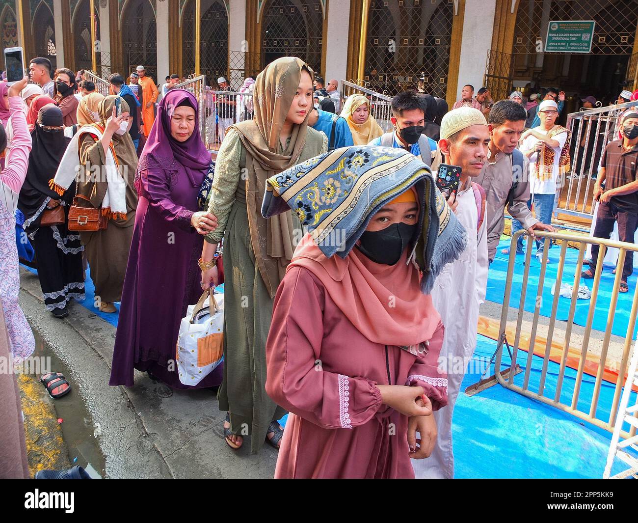 Muslim females leaving the Golden Mosque after listening to the sermon and prayer of the Imam in Quiapo, Manila. Muslim families as well as foreigners finally celebrate Eid al-Fitr today April 22 or the end of Ramadan after a one day halt because the mooncrescent was not sighted last Friday, April 21. Muslims visit the Masjid Al-Dahab or the Manila Golden Mosque & Cultural Center in Quiapo district of Manila, where they can gather together with the other faithful to listen 'khutbah' or the sermon and offer prayers. Stock Photo