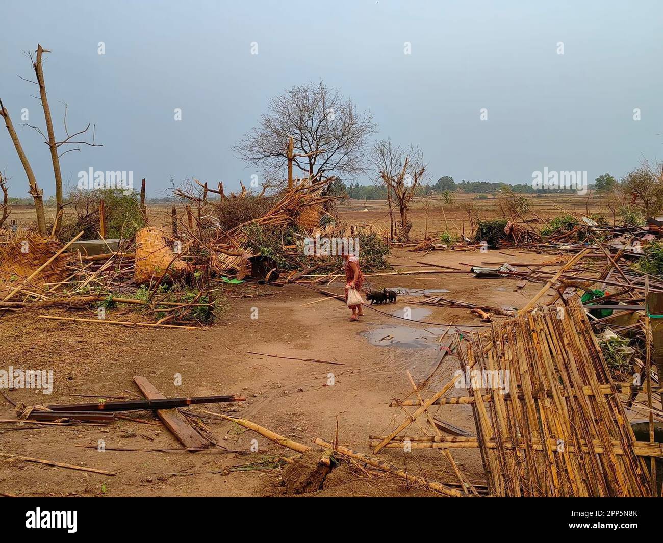 (230422) -- NAY PYI TAW, April 22, 2023 (Xinhua) -- This photo taken with mobile phone on April 21, 2023 shows a woman walking by damaged houses after a tornado hits Lewe township of Nay Pyi Taw Union Territory, Myanmar. Six people were killed and 109 others injured after a deadly tornado hit central Myanmar on Friday, local authorities said. (Str/Xinhua) Stock Photo
