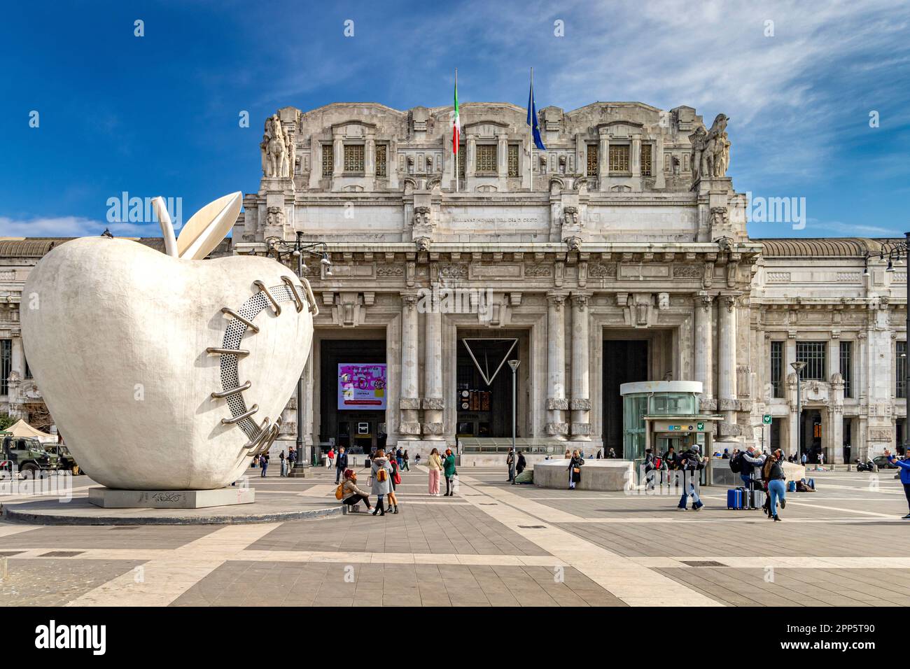 The big apple of Milan, a sculpture by Michelangelo Pistoletto, outside the grand exterior of  Milano Centrale railway station,Milan ,Italy Stock Photo