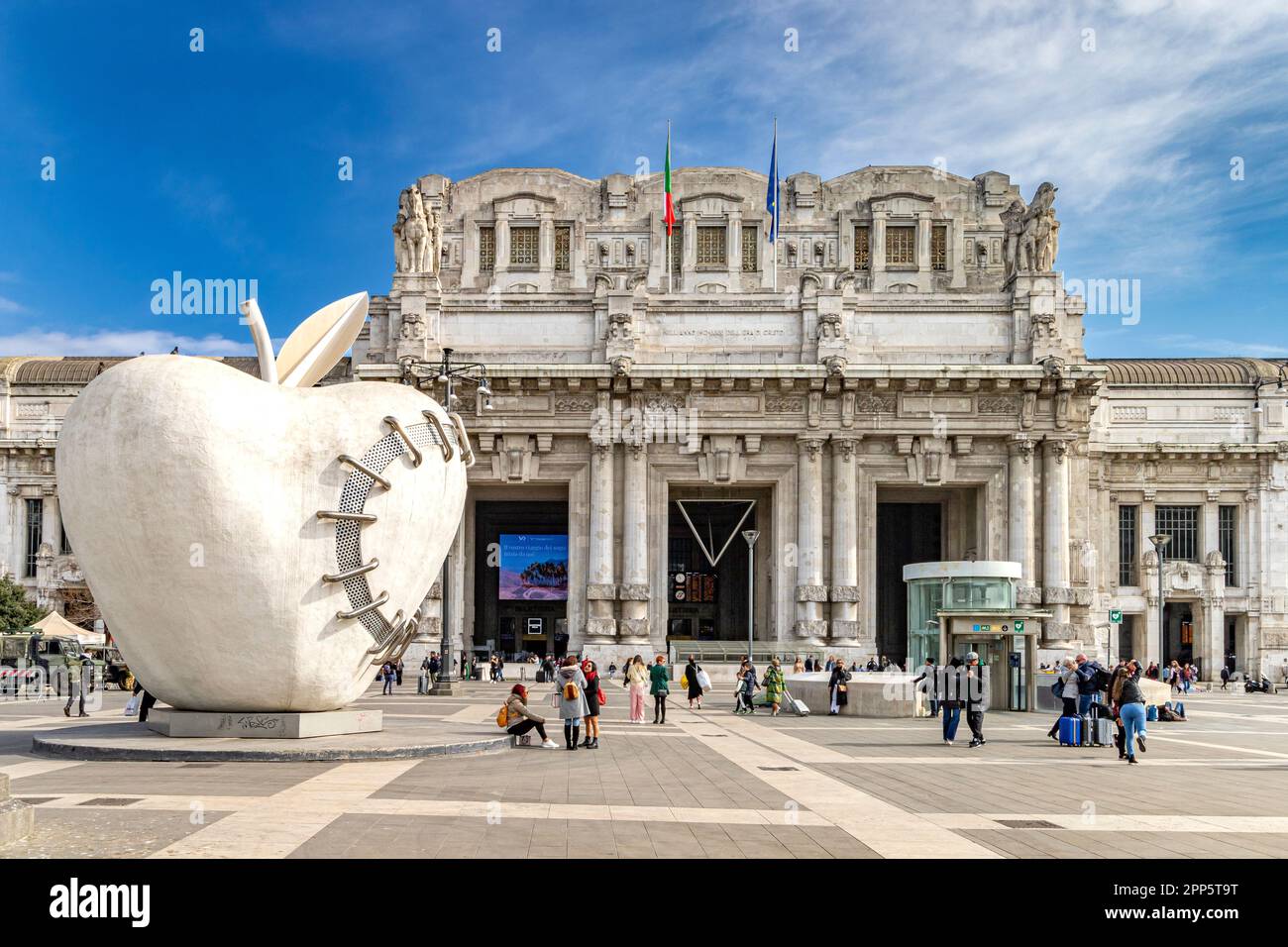 The big apple of Milan, a sculpture by Michelangelo Pistoletto, outside the grand exterior of  Milano Centrale railway station,Milan ,Italy Stock Photo