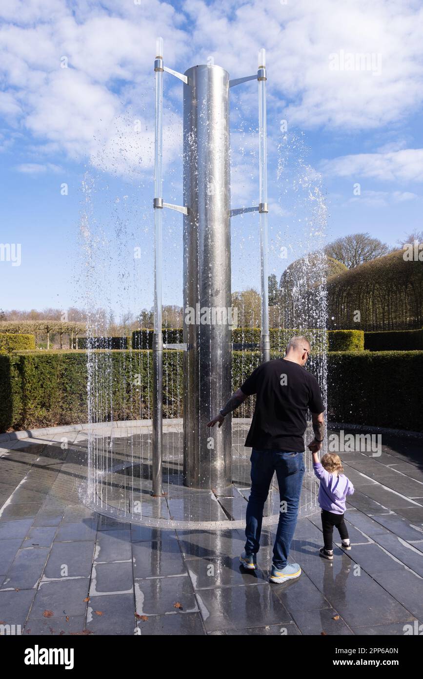 A family with children playing in the fountain section in spring