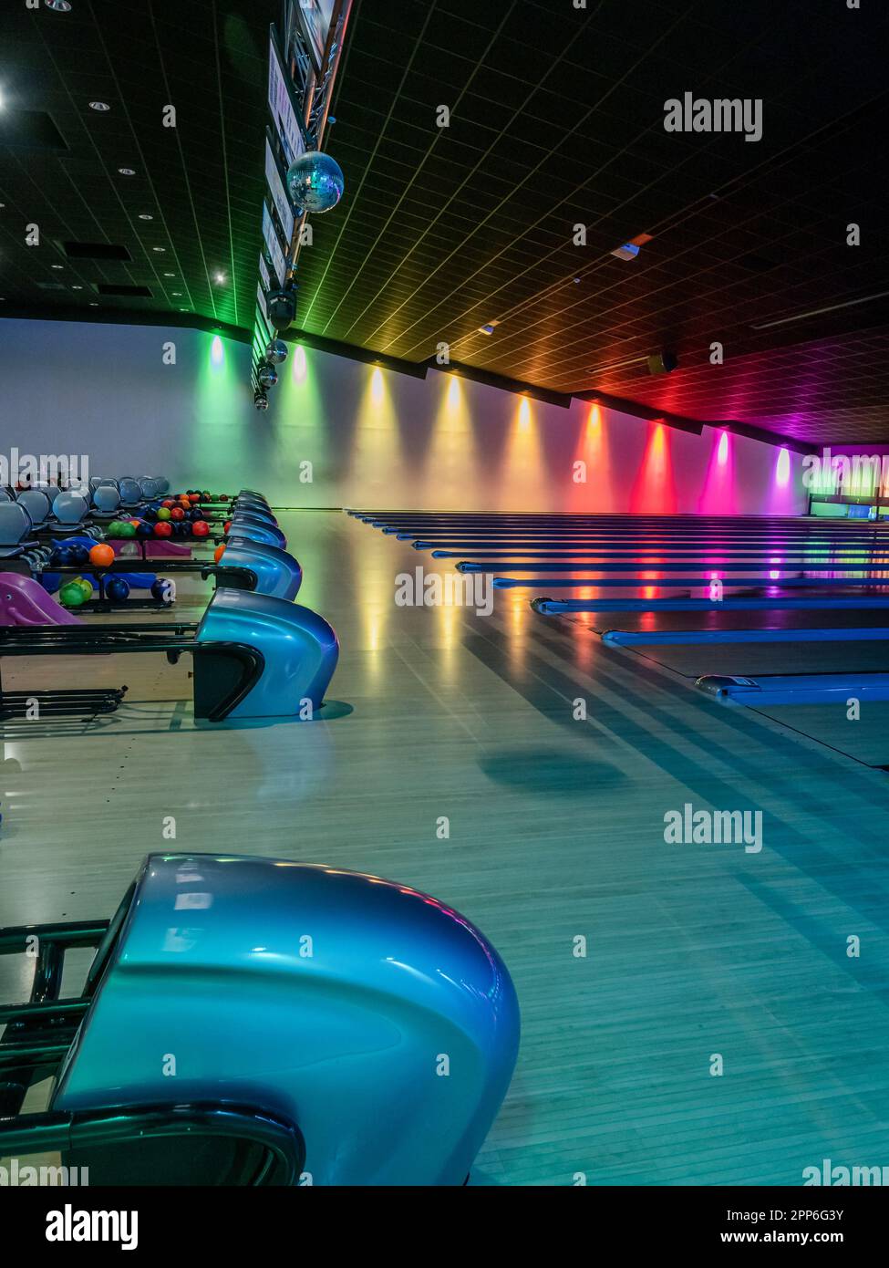 Multicolored illumination of lanes in a huge bowling alley. Empty hall