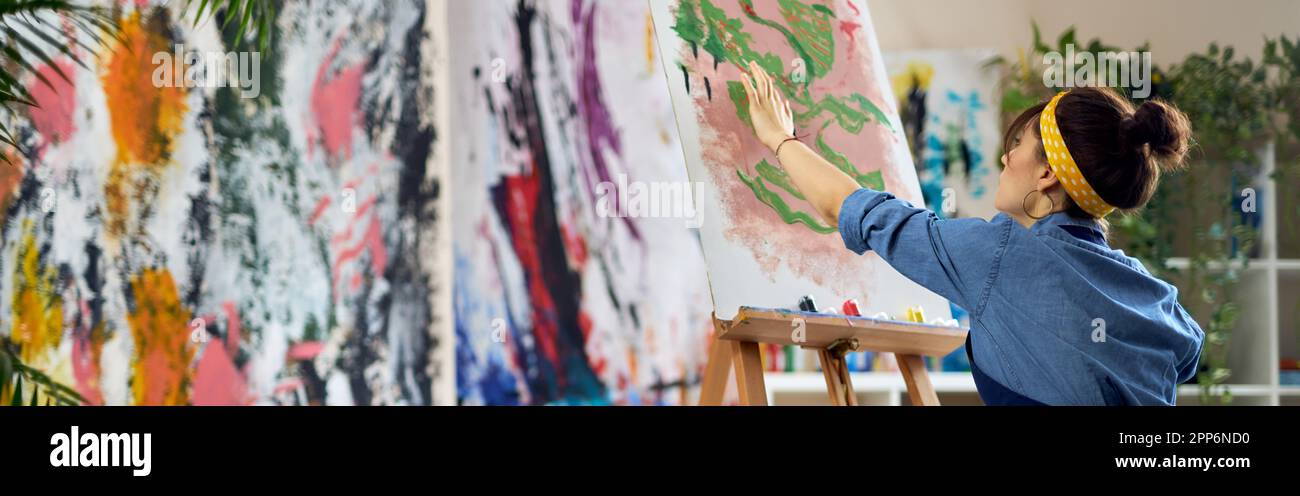 Inspired woman, female artist in apron creating abstract painting at ...