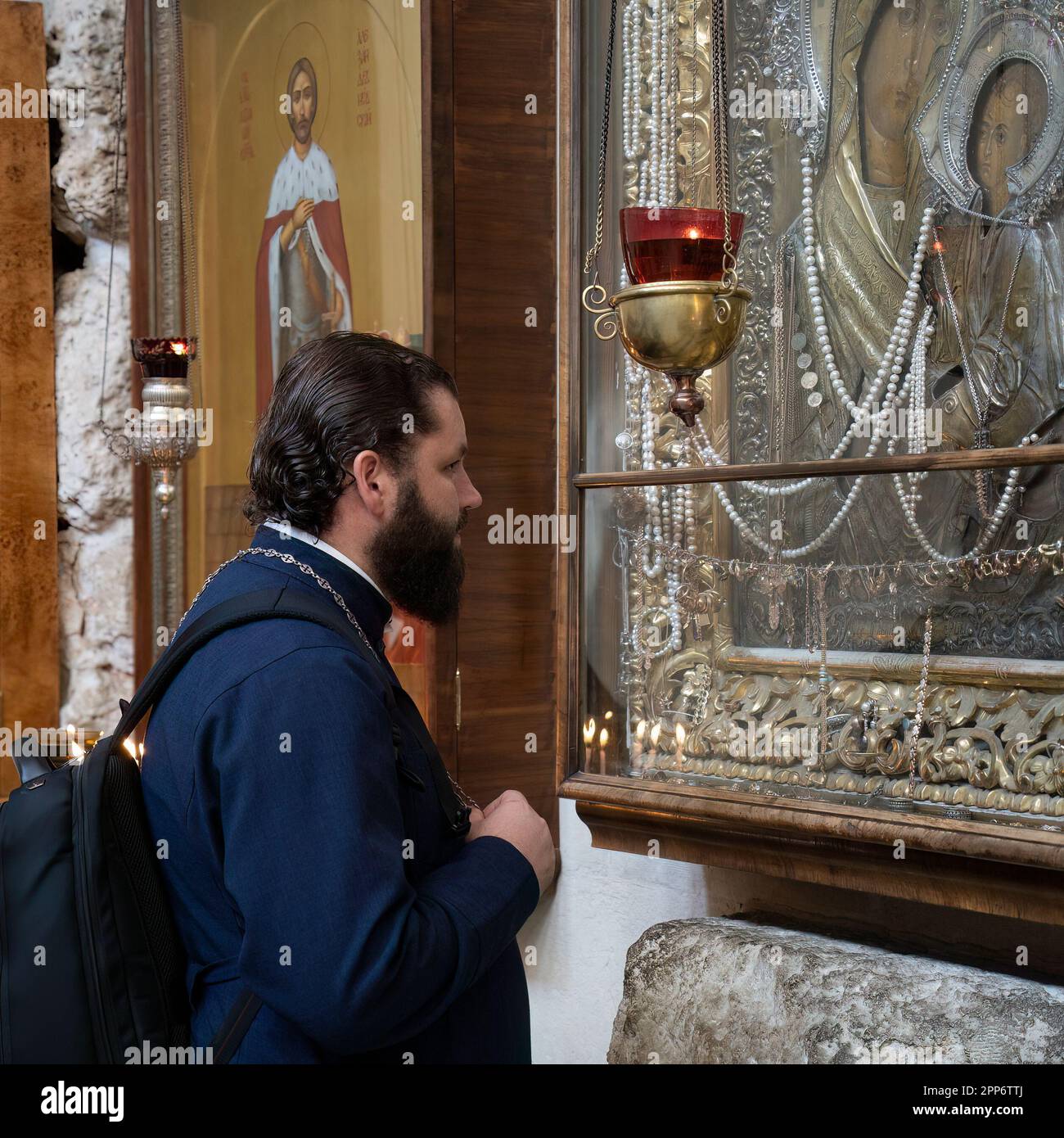 Jerusalem, Israel - November 12th, 2022:A russian orthodox priest looking at icons in the church of Saint Alexander Nevsky, the old city of Jerusalem, Stock Photo