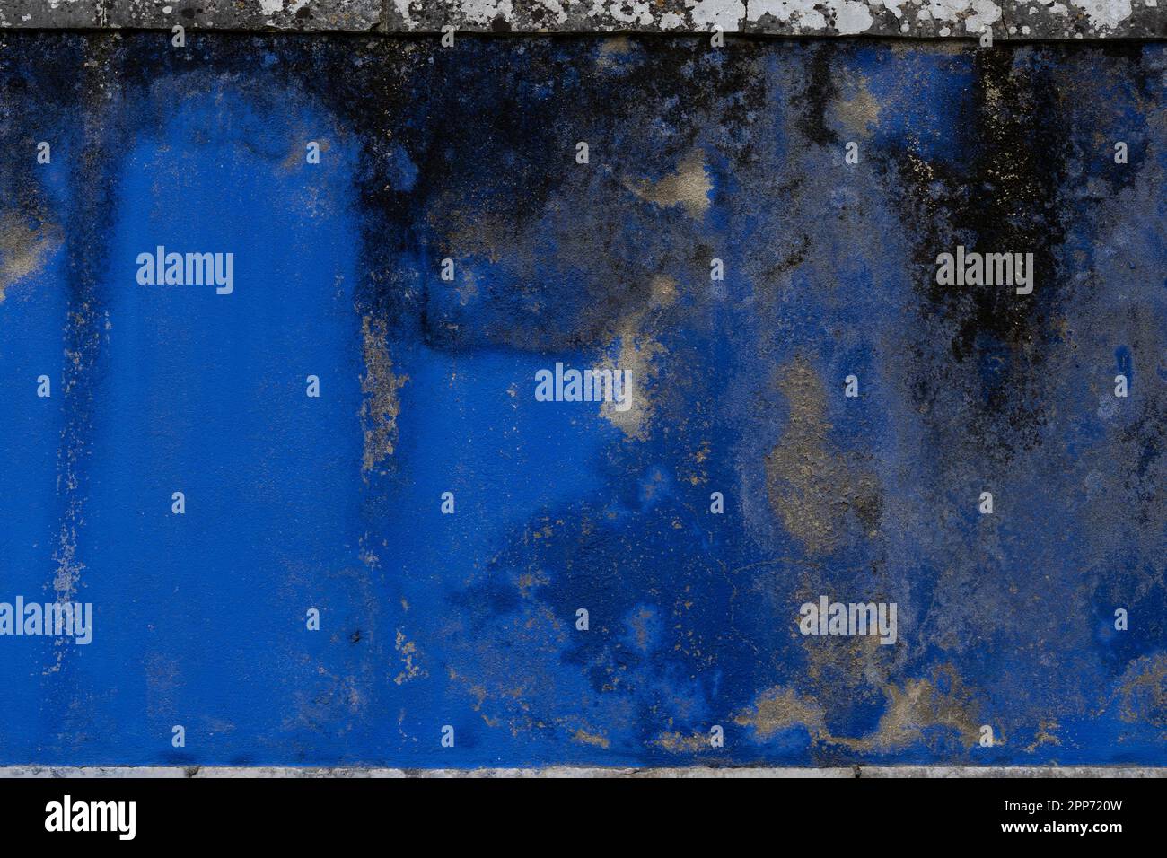 Blue weathered moldy wall with peeling off layers of paint Stock Photo