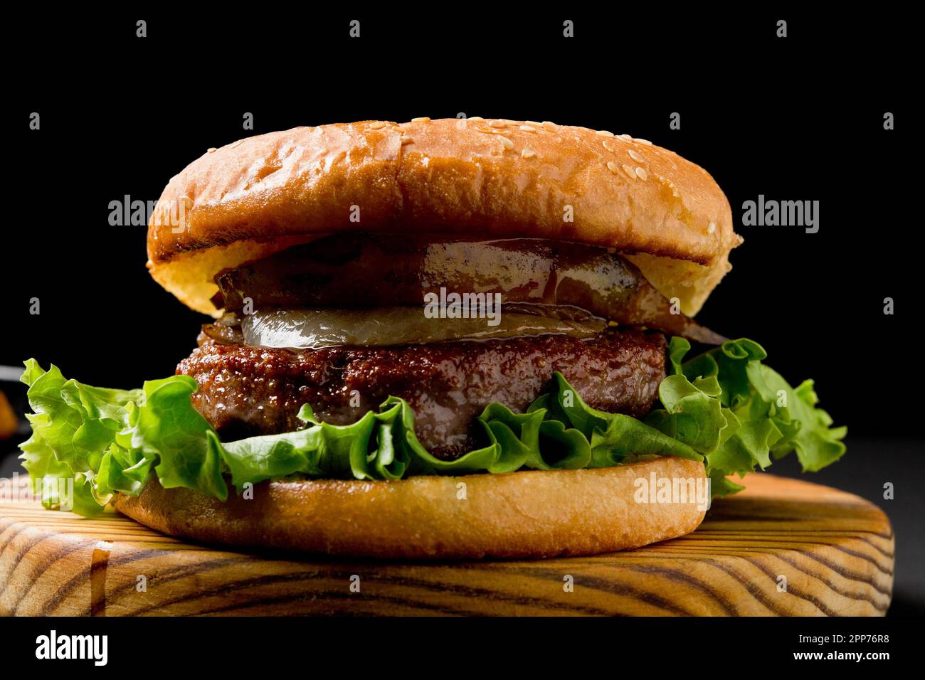 Beef burger. With mustard and ketchup, lettuce and onion. Black