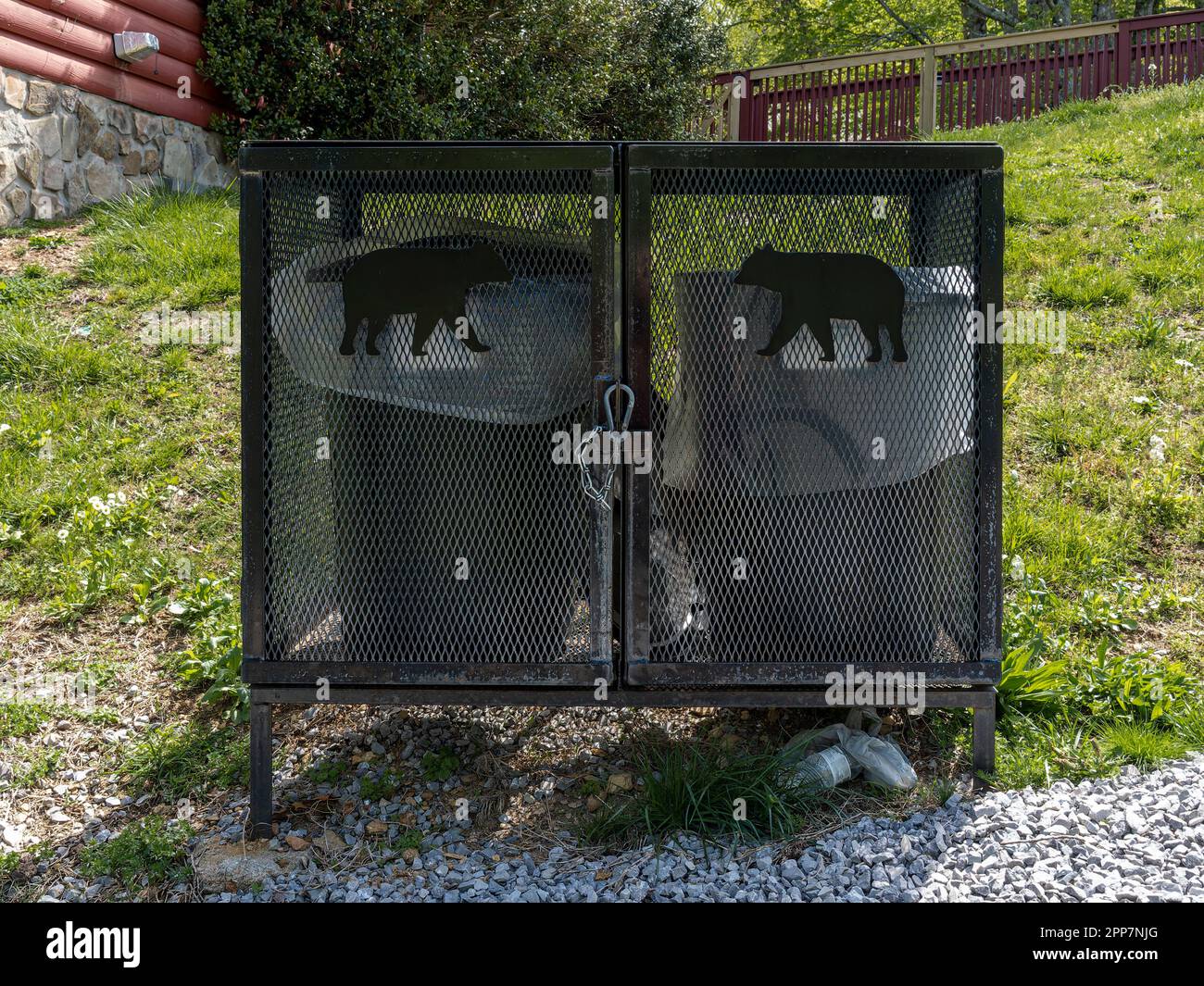 Bear proof garbage can container or anti bear garbage cans next to a log cabin in the Smokey Mountains near Pigeon Forge Tennessee, USA. Stock Photo