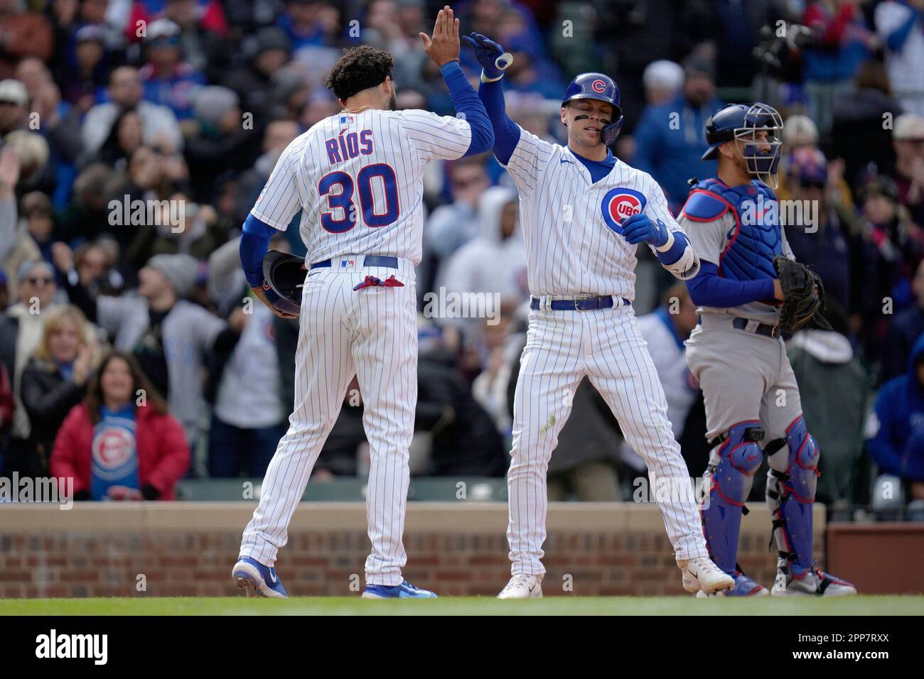 Chicago Cubs' Nico Hoerner, right, high-fives Chicago Cubs' Edwin
