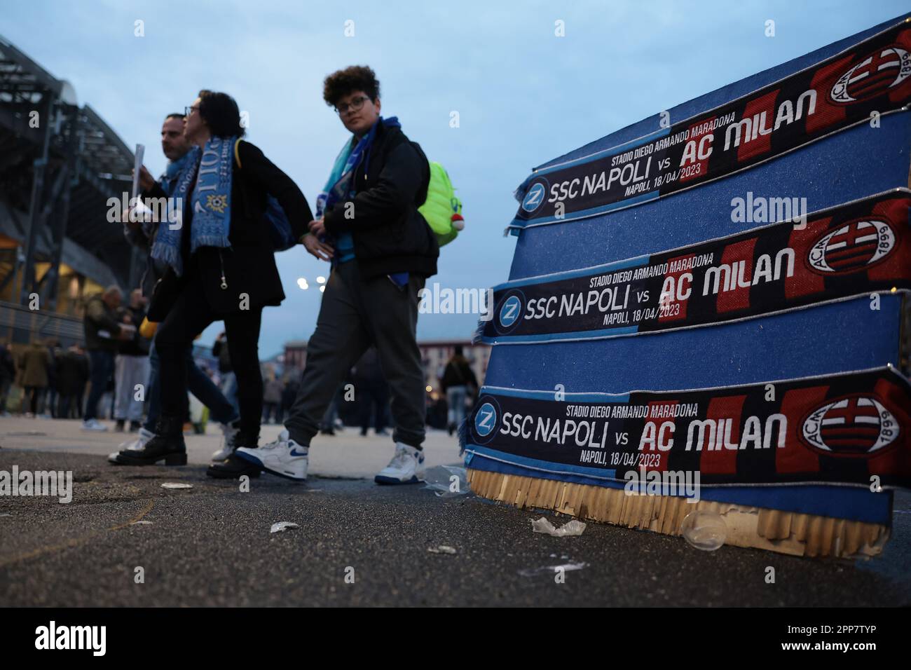 Naples, Italy, 18th April 2023. Fans walk past a board displaying half and half scarves to commemorate the match for sale outside the stadium prior to the UEFA Champions League match at Stadio Diego Armando Maradona, Naples. Picture credit should read: Jonathan Moscrop / Sportimage Stock Photo
