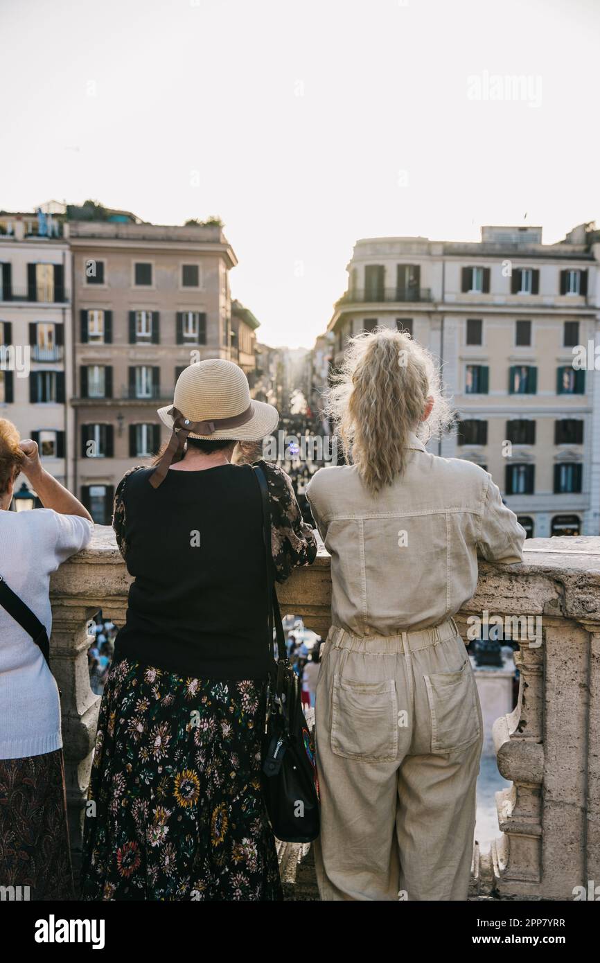 Two women looking out over the city of Rome, Italy from the Spanish steps at sunset on a clear, beautiful evening Stock Photo