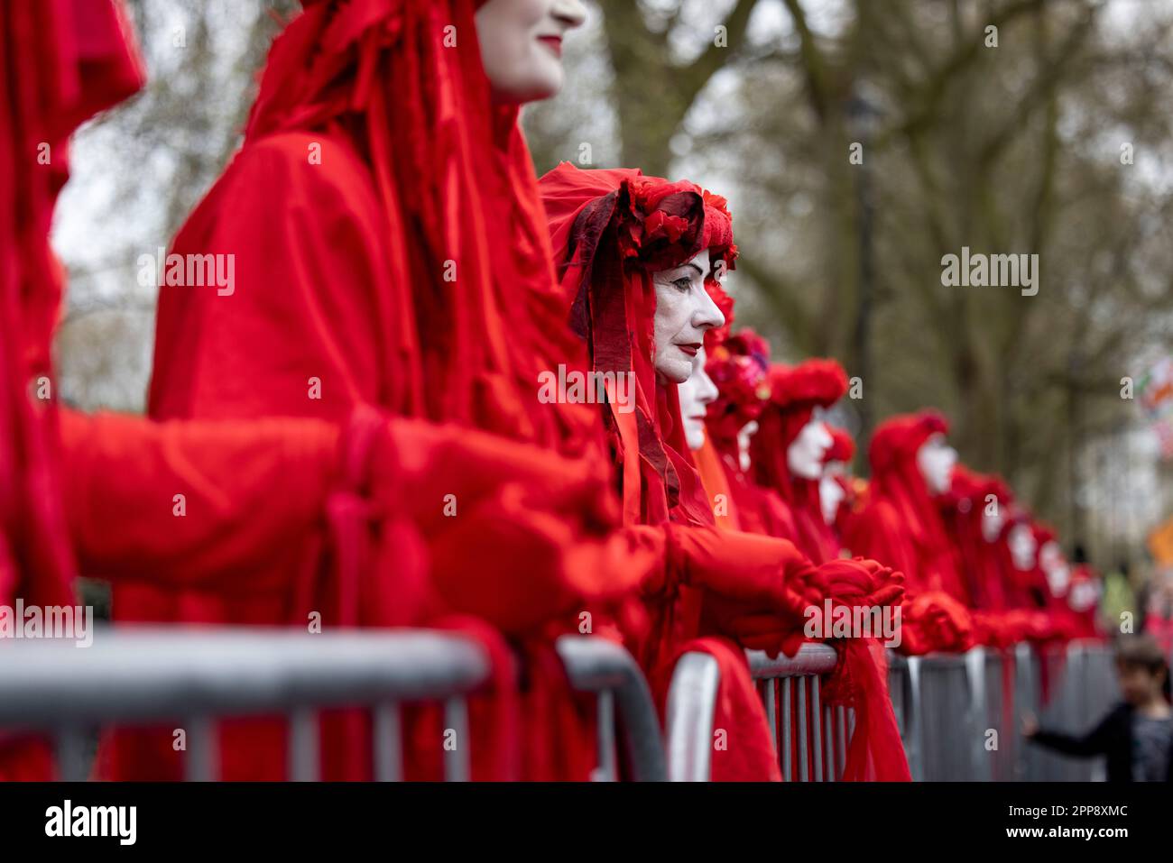 London, UK. 22nd Apr, 2023. Protesters seen dressing as red brigades hold hands to urge the UK government to view climate crisis as a matter of emergency during the march in Westminster. Extinction Rebellions, a mass group of activists from different discipline with their primary concern on climate crisis, continue the second day of their mass campaign on the Earth Day. This is the first campaign since the group pledged to move away from controversial disruptive methods since late last year. Credit: SOPA Images Limited/Alamy Live News Stock Photo