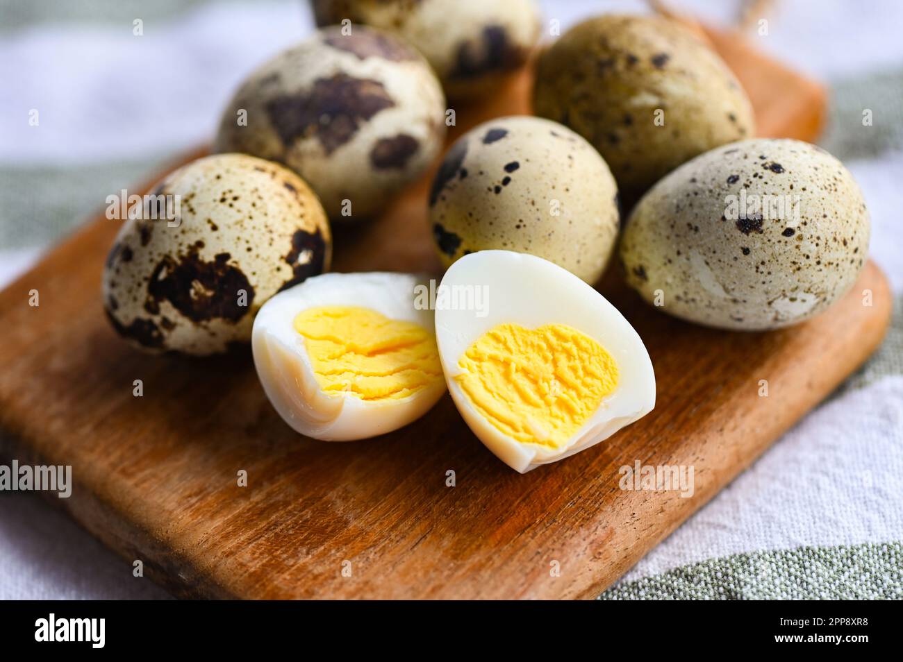 boiled eggs food, quail eggs on wooden plate, breakfast eggs with fresh quail eggs on table background Stock Photo