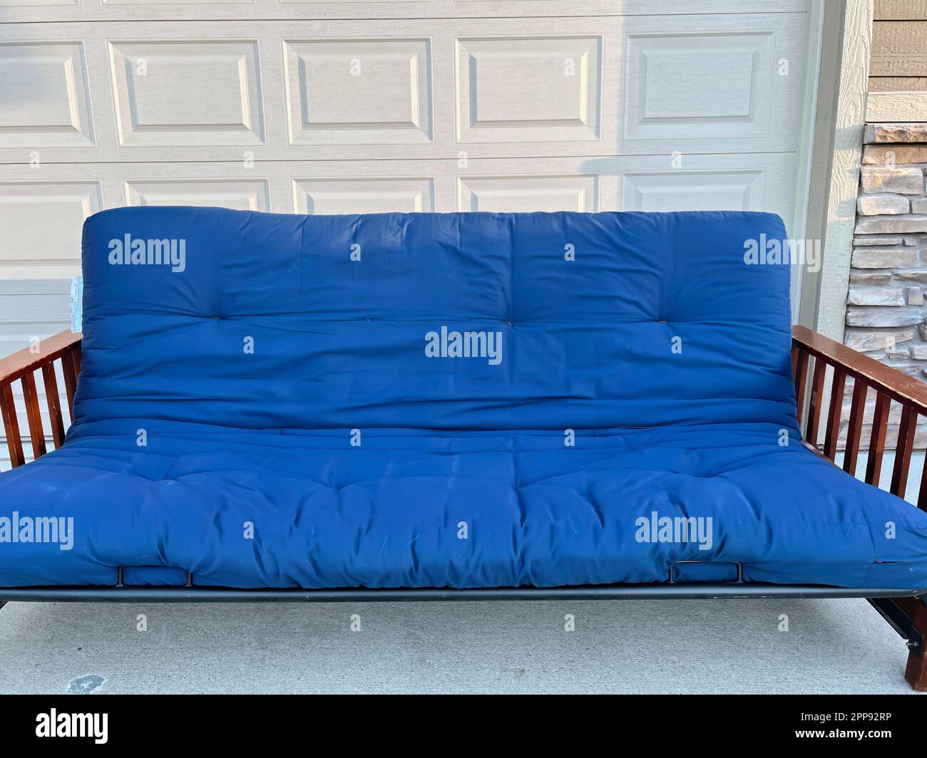 futon and frame on the sidewalk driveway of a house for free pickup Stock Photo Alamy