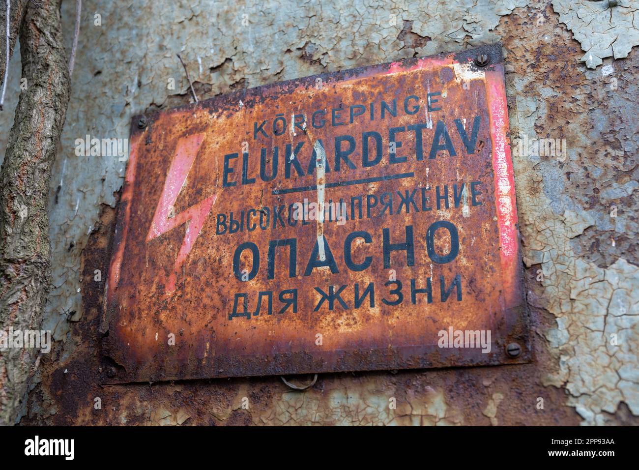 Rusty old Soviet-era sign warning of high voltage electricity. Telliskivi district of Tallinn, Estonia. Stock Photo