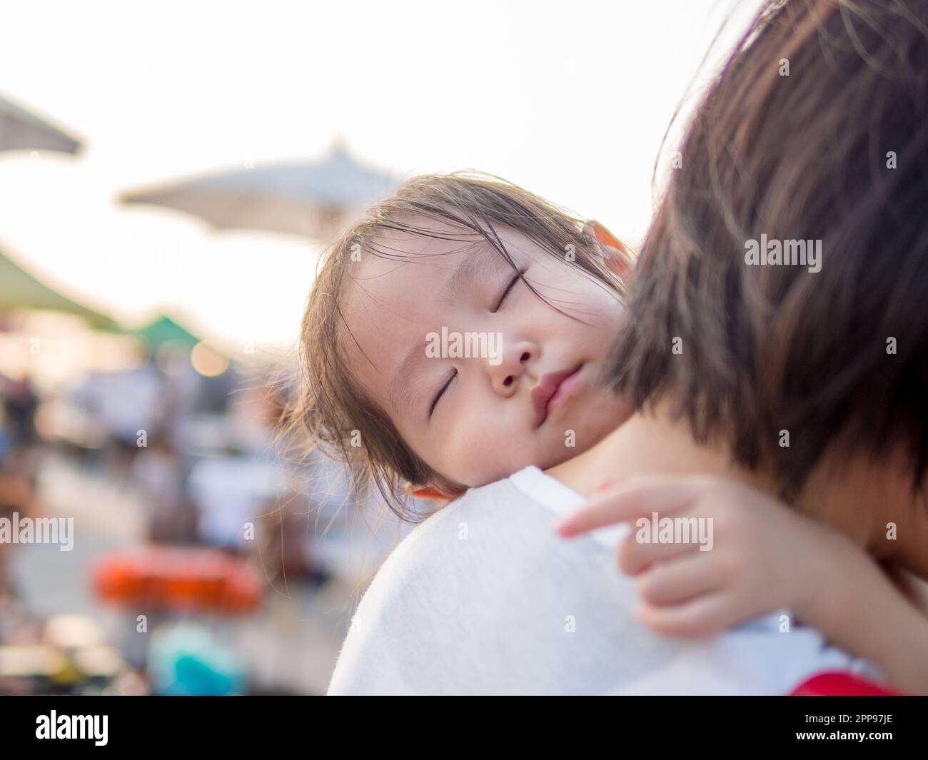 Asian baby girl hugging her mother , sleeping Stock Photo