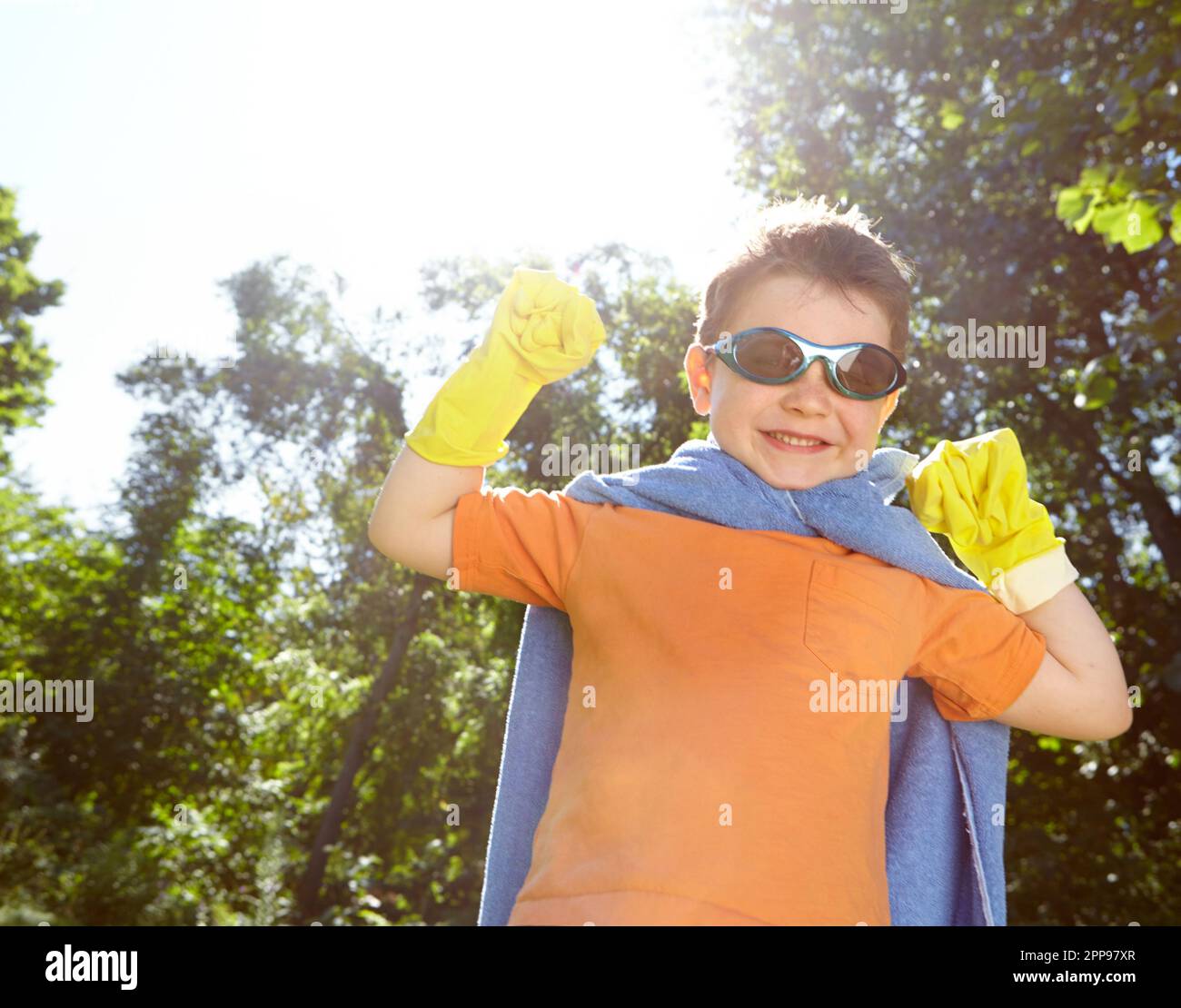 Heroics in the garden. A playful little boy dressed as a superhero at home. Stock Photo