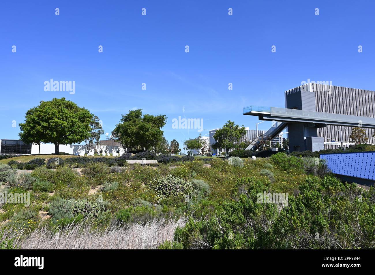 NEWPORT BEACH, CALIFORNIA - 22 APR 2023: Pedestrian bridge ove San Miguel Drive at Avocado Ave connecting the two halves of Civic Center Park with off Stock Photo