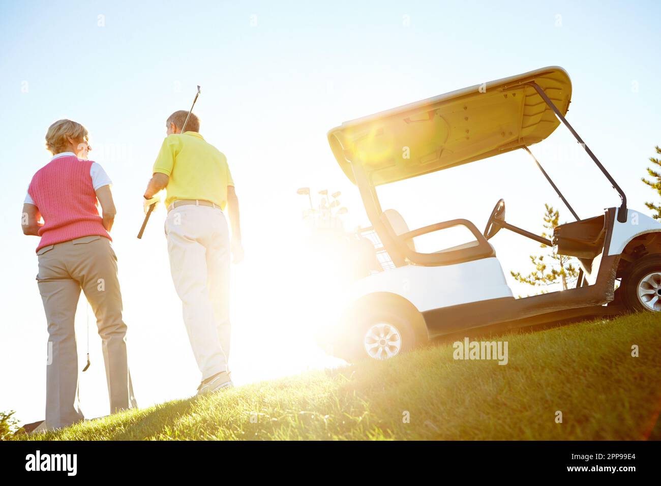 Walking off into the sunset. Rear view shot of an elderly couple walking to their golf cart. Stock Photo