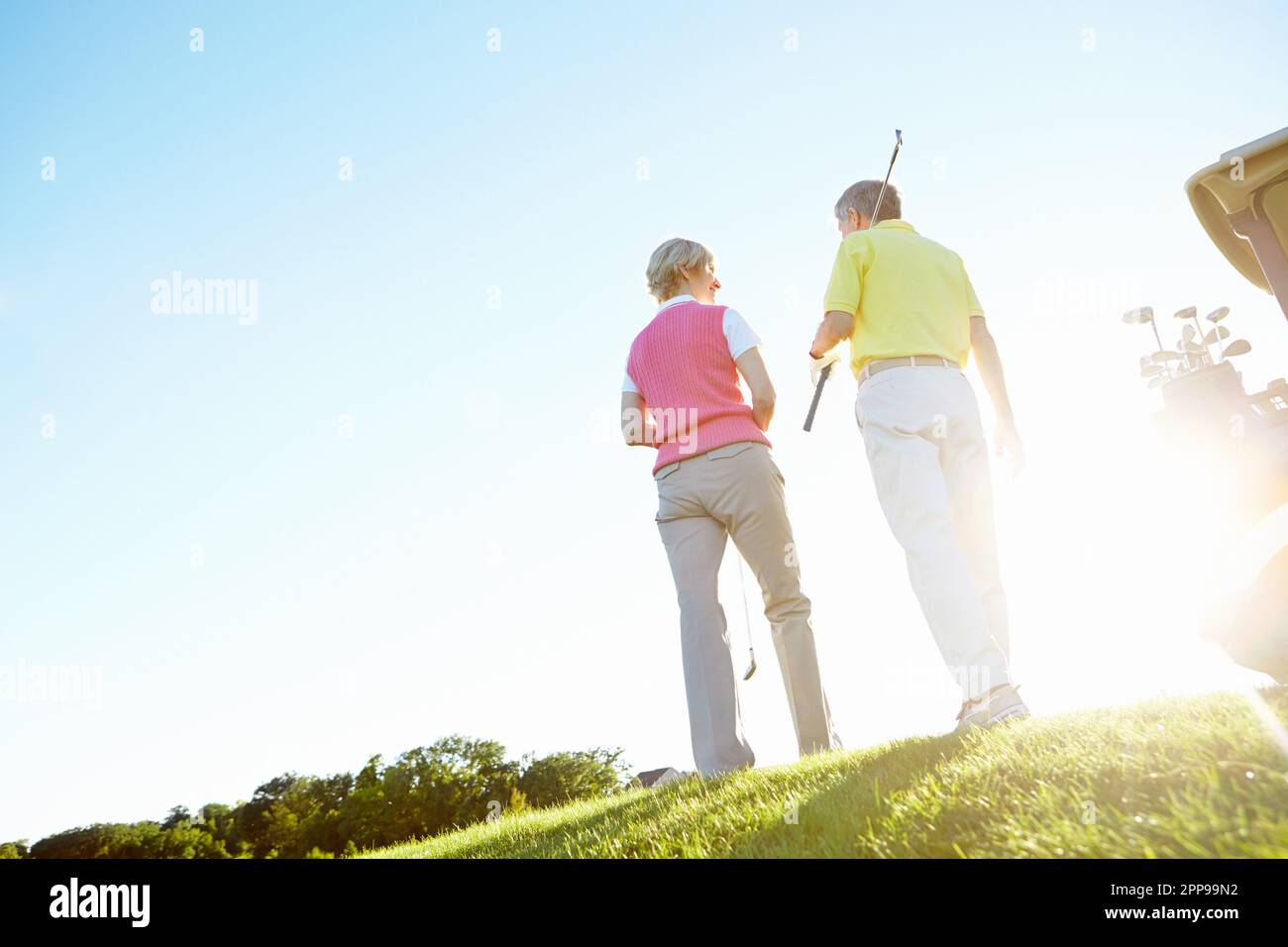 Theyve had a great game. Rear view shot of an elderly couple walking to their golf cart. Stock Photo