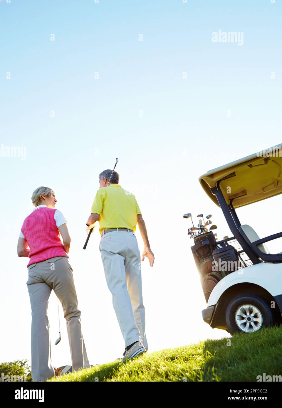 After a day of good golf. Rear view shot of an elderly couple walking to their golf cart. Stock Photo