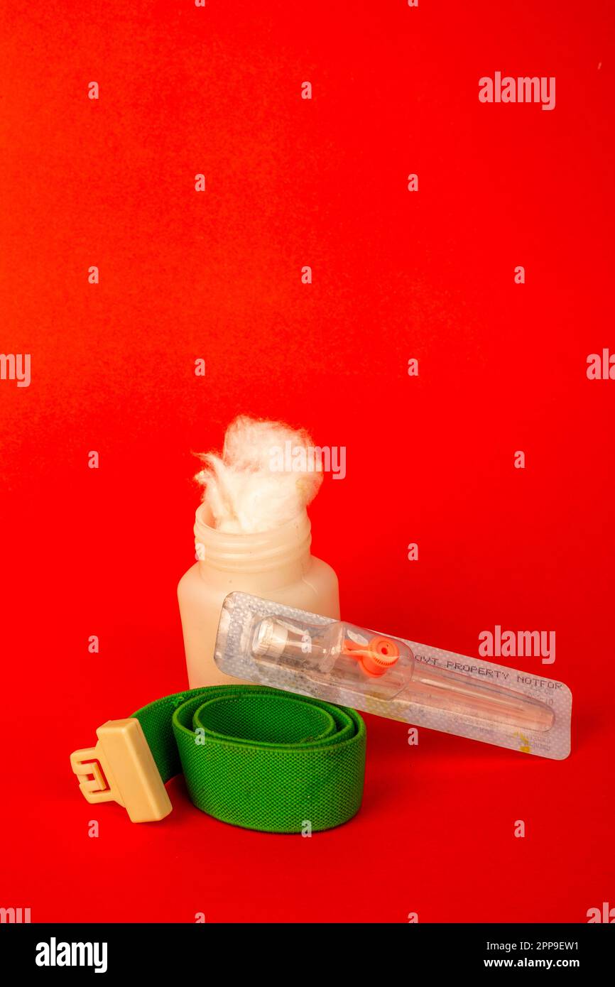 Cotton fiber texture in the white bottle with iv cannula . isolated on red background Stock Photo