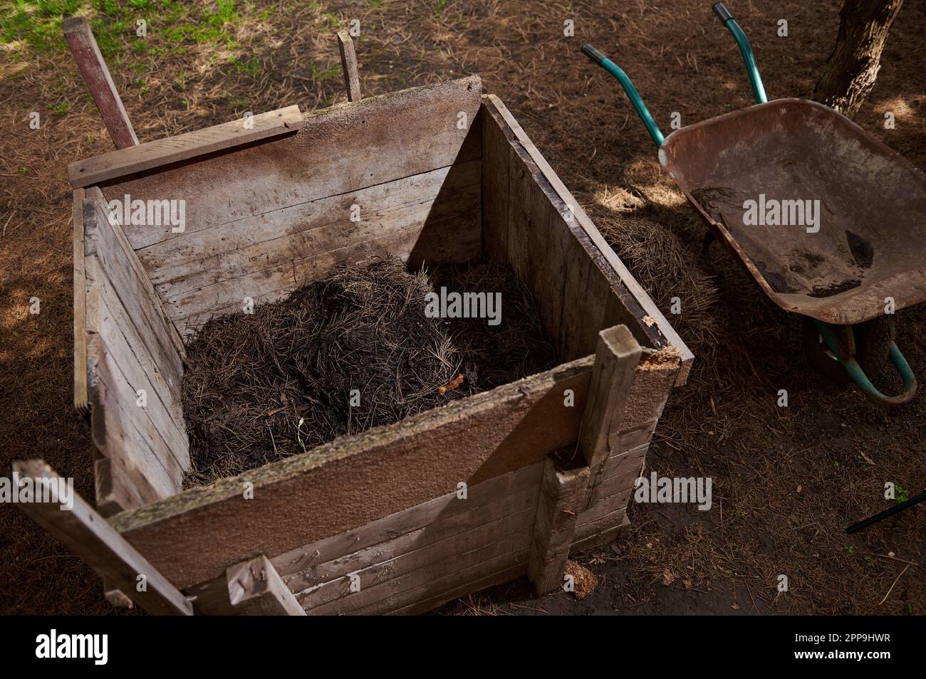 Compost heap. Compost pit on the plot of land. Wooden box for fertilizer and waste. Humus with