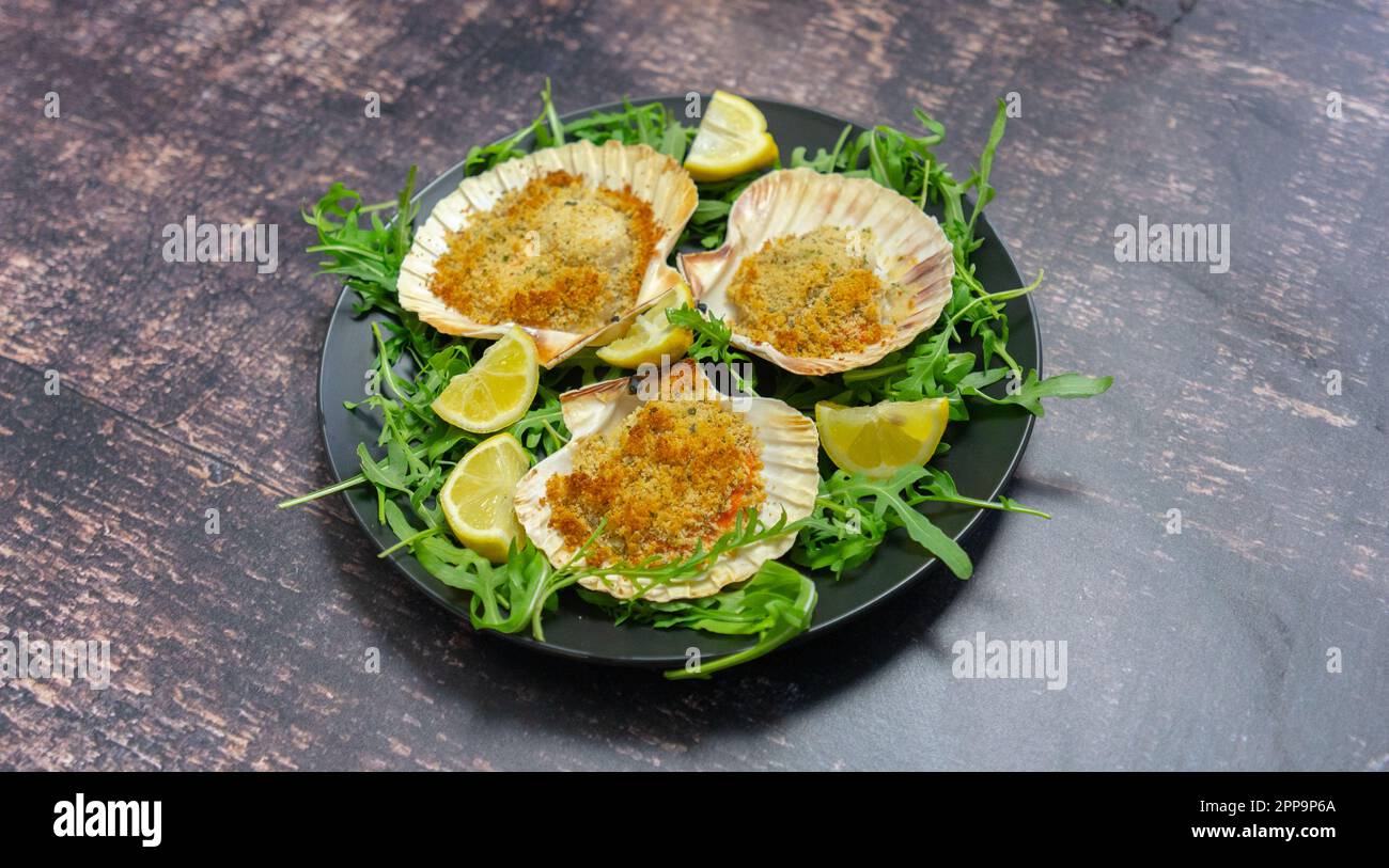 scallops au gratin cooked in the oven with parsley and lemon Stock