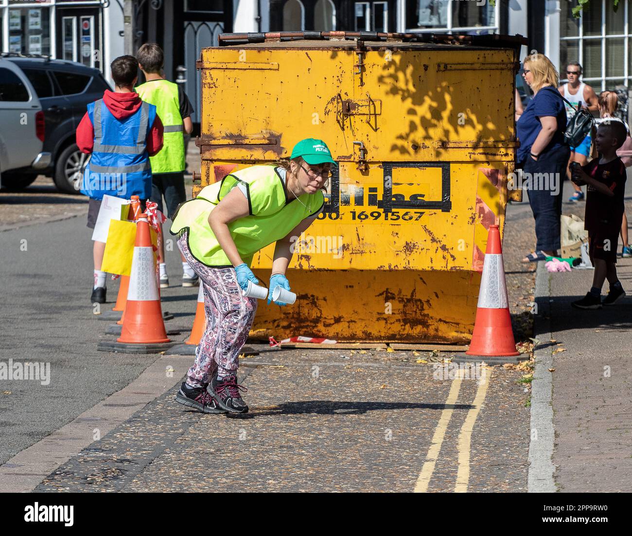 A marshal tidying up at the water station after the Framlingham Flyers 10km road race Stock Photo