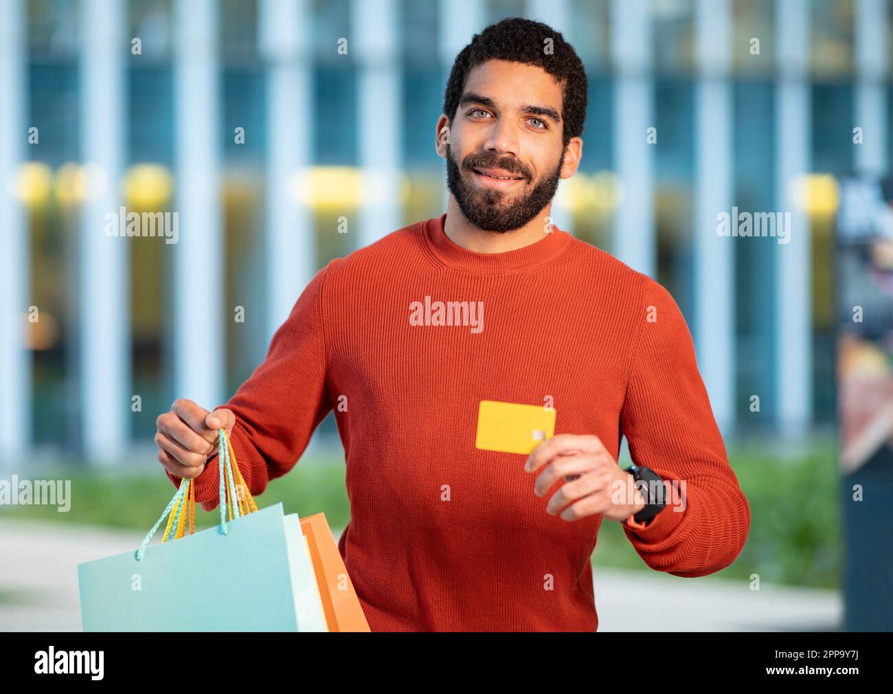 Middle Eastern Buyer Guy Showing Credit Card Advertising Bank Outside Stock Photo