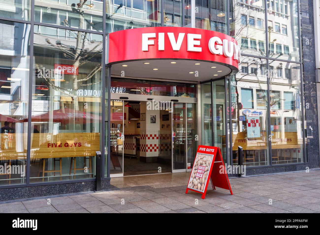 Stuttgart, Germany - April 10, 2023: Five Guys fast food hamburger restaurant brand with logo in Stuttgart, Germany. Stock Photo