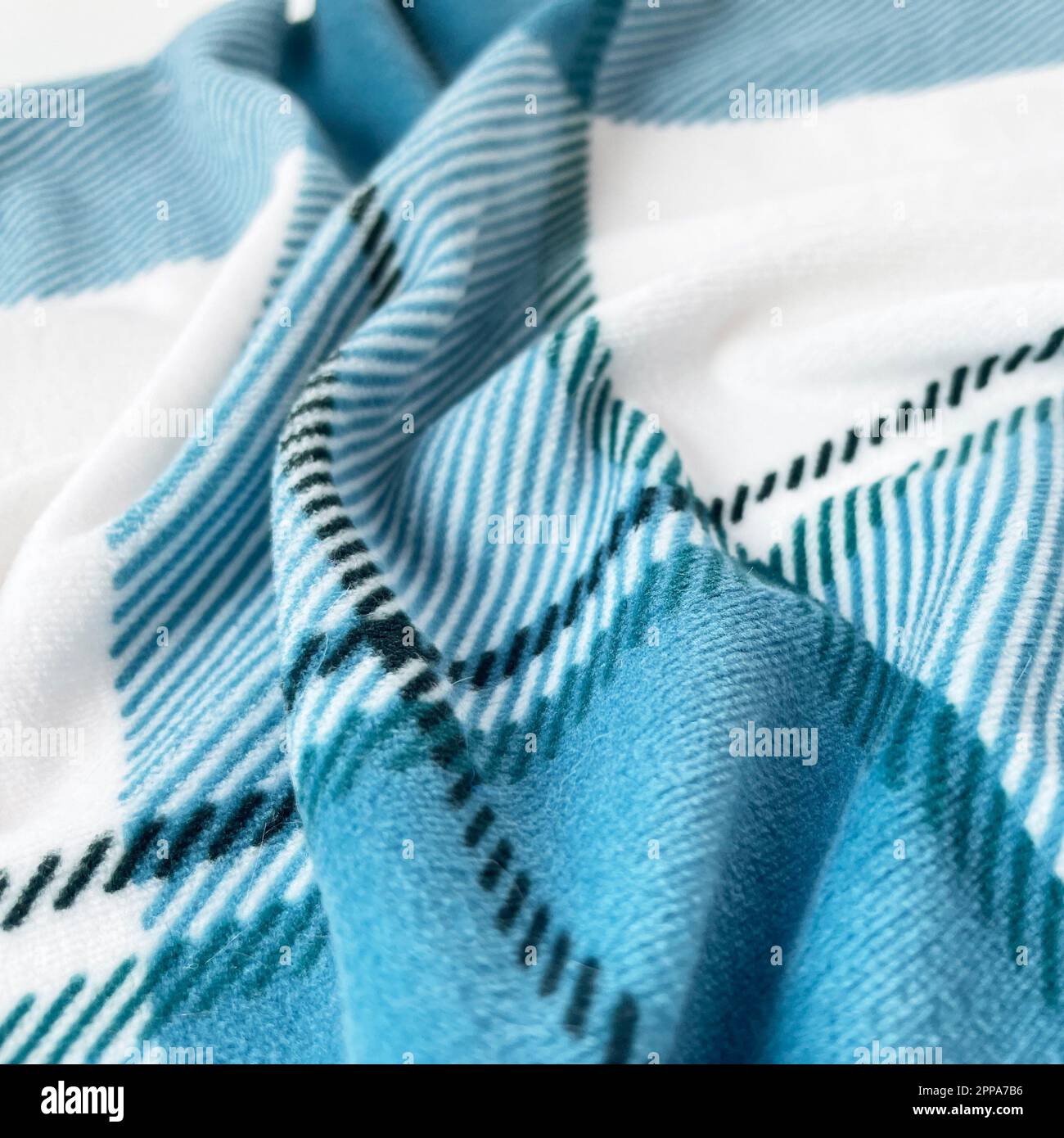 A close up shot of plaid blue and white fabric on a white background Stock Photo