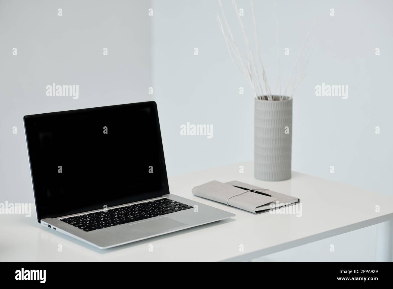 Laptop with empty screen and planner on office table Stock Photo
