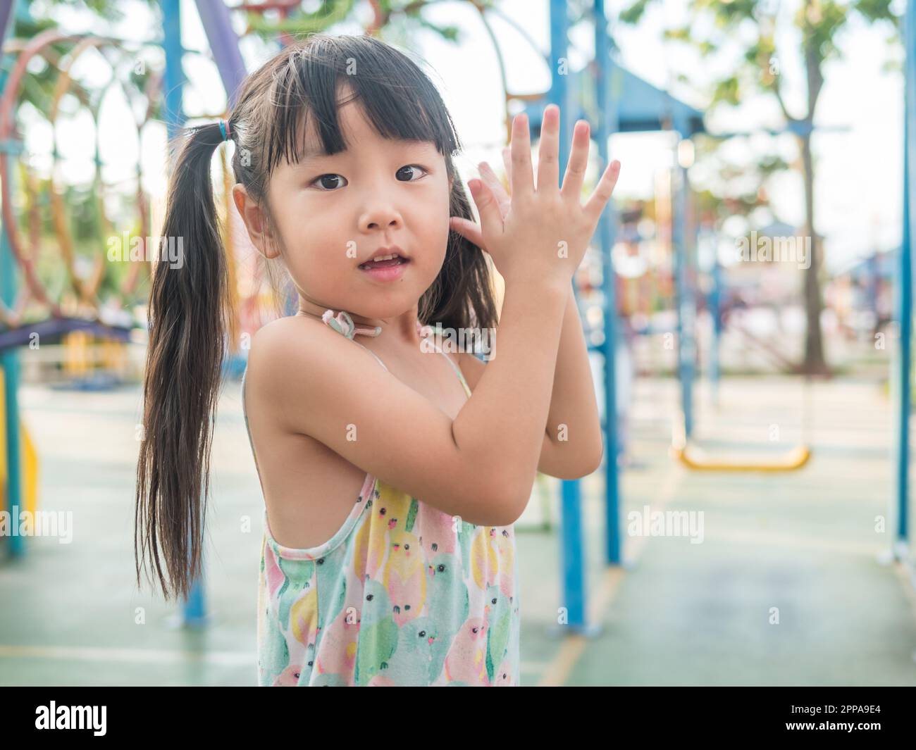 asian baby child playing on playground, clap her hands action Stock