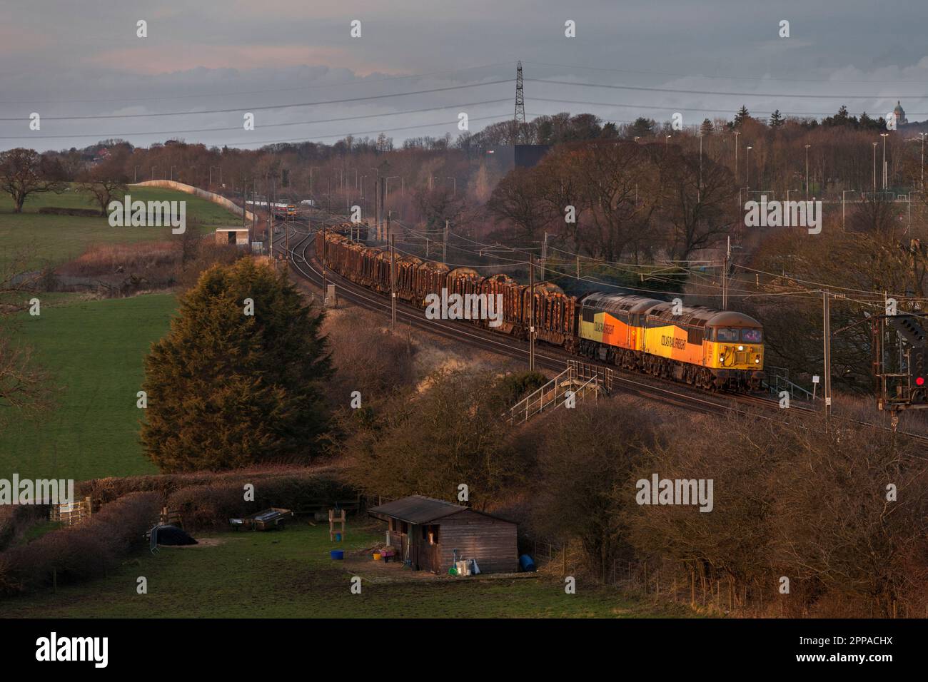 Colas Railfreight class 56 locomotives 56094 + 56090 hauling a long freight train carrying timber on the west coast mainline Stock Photo