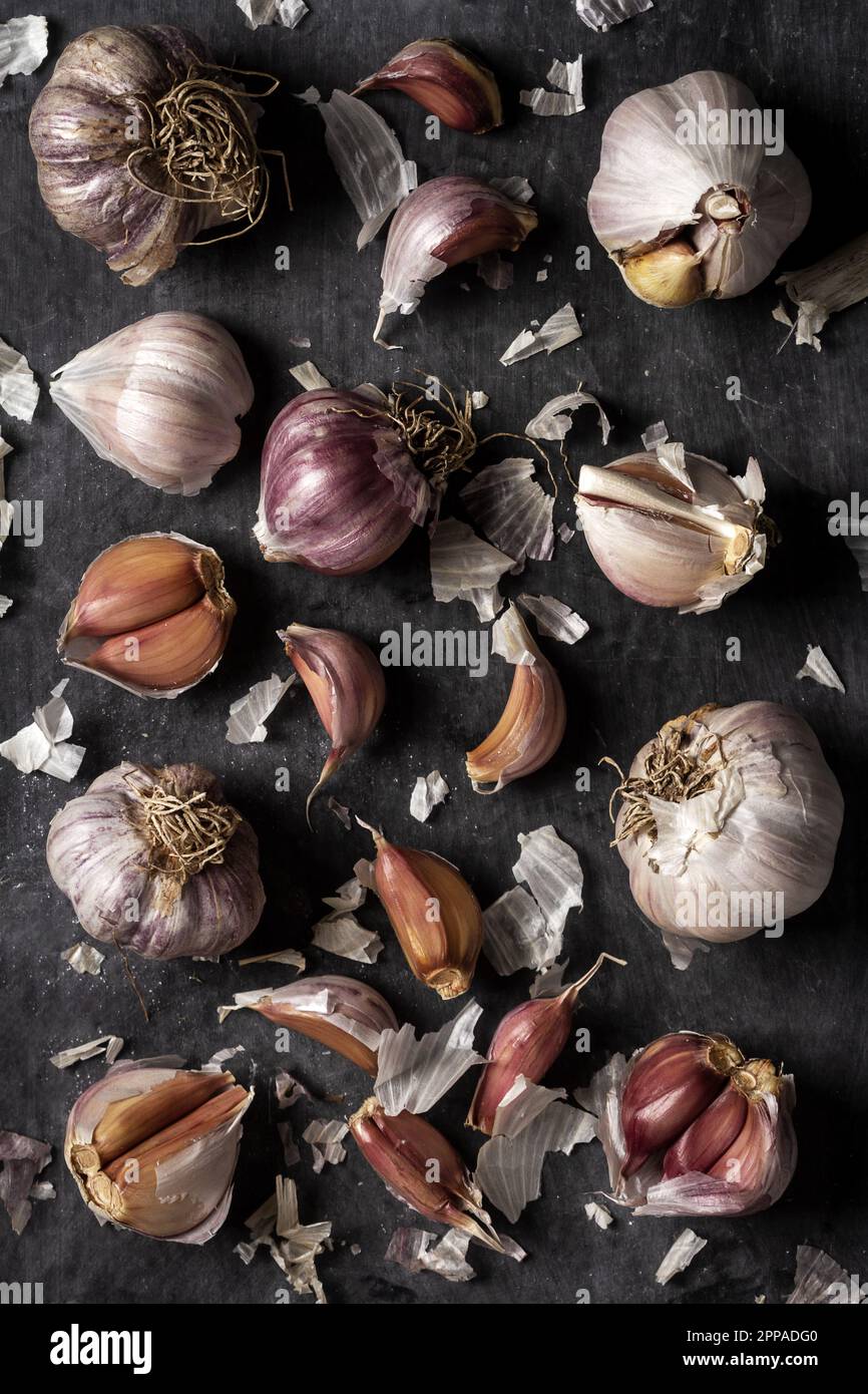Fresh garlic bulbs and cloves grouped on black background. Flat lay ...