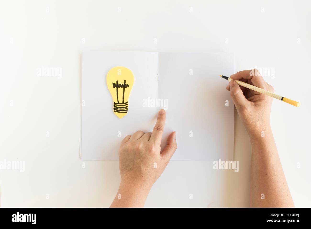 Human hand writing card with light bulb Stock Photo