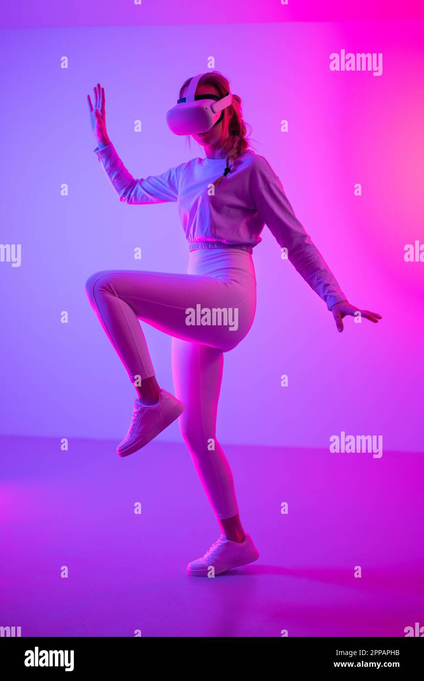 Fit woman doing workout using virtual reality headset Stock Photo