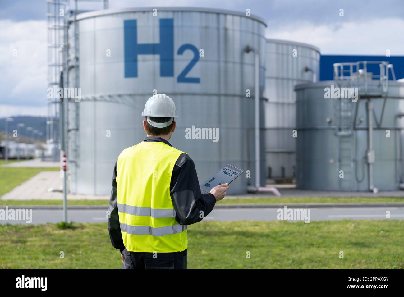 Engineer with tablet computer on a background of Hydrogen factory. High quality photo Stock Photo