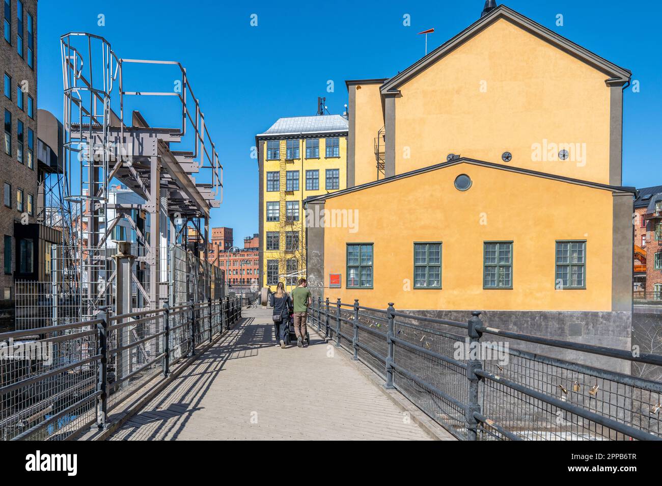 People walk in the historic industrial landscape of Norrköping during spring in Sweden Stock Photo