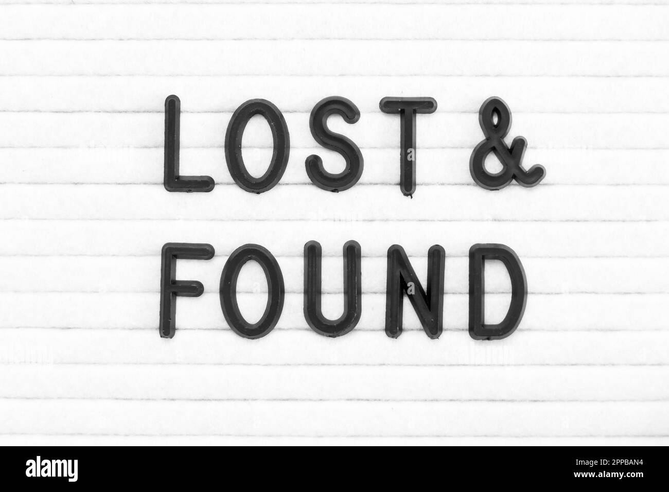 Black color letter in word lost and found on white felt board background Stock Photo