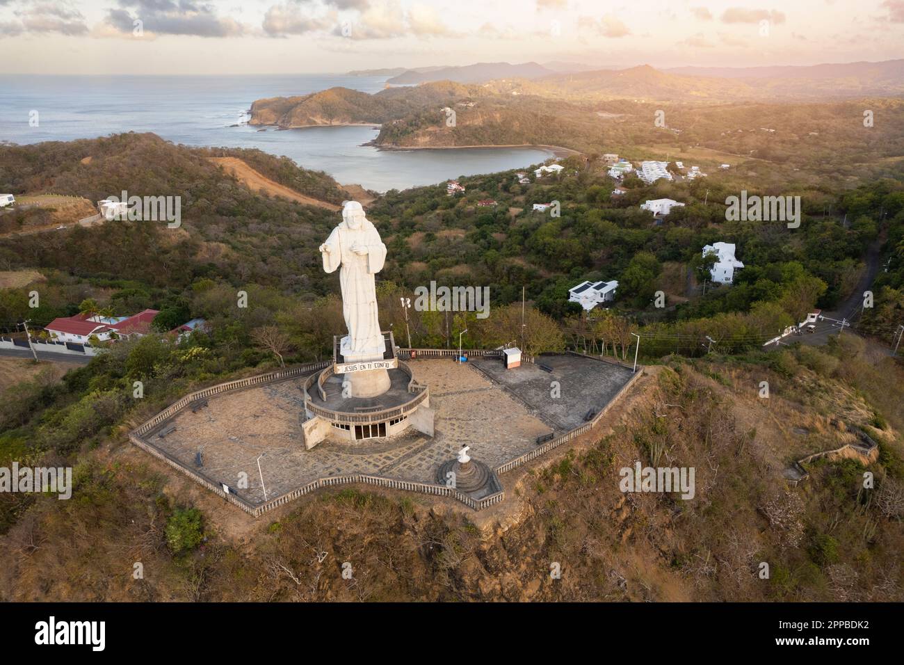 Jesus Christ statue in gold color sunrise light aerial drone view in