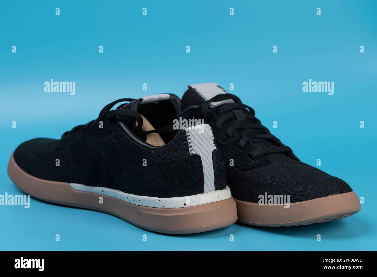 Pair of black casual shoes with laces isolated on blue studio background Stock Photo