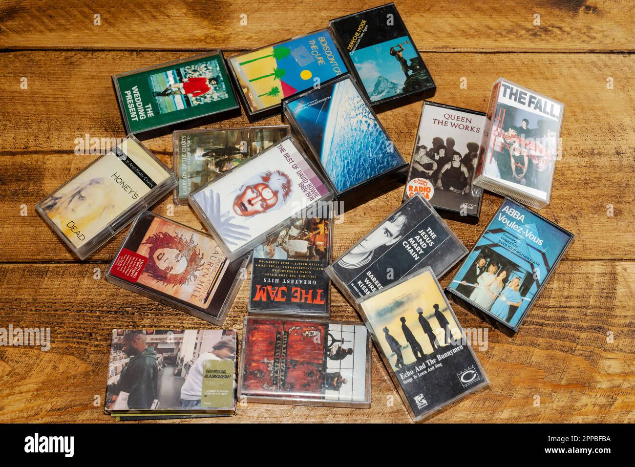 A collection of original music cassette tapes from the 1970s - 1990s, strewn on a wooden table, as cassette tape sales hit a 20 year high this month. Stock Photo