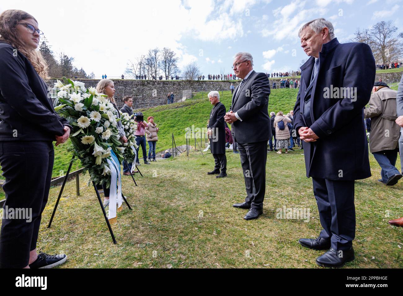 23 April 2023, Bavaria, Flossenbürg: Karl Freller (r-l, CSU), Director of the Bavarian Memorials Foundation, Joachim Herrmann (CSU), Minister of the Interior of Bavaria, and Heinrich Bedford-Strohm, Bishop of the Evangelical Lutheran Church in Bavaria, stand at a wreath in the so-called 'Valley of Death' to commemorate the victims of the concentration camp during the commemoration of the 78th anniversary of the liberation of Flossenbürg concentration camp. Flossenbürg concentration camp had been liberated by the US Army on April 23, 1945. Of about 100,000 people imprisoned there or in the subc Stock Photo